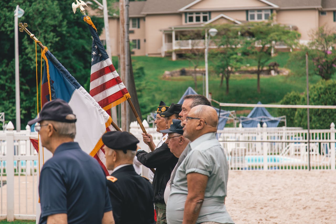 gallery-2 Group of veterans holding flags during an outdoor ceremony showing patriotism.