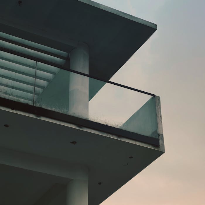 about-01 Sleek modern balcony in minimalistic architecture against a cloudy sky.