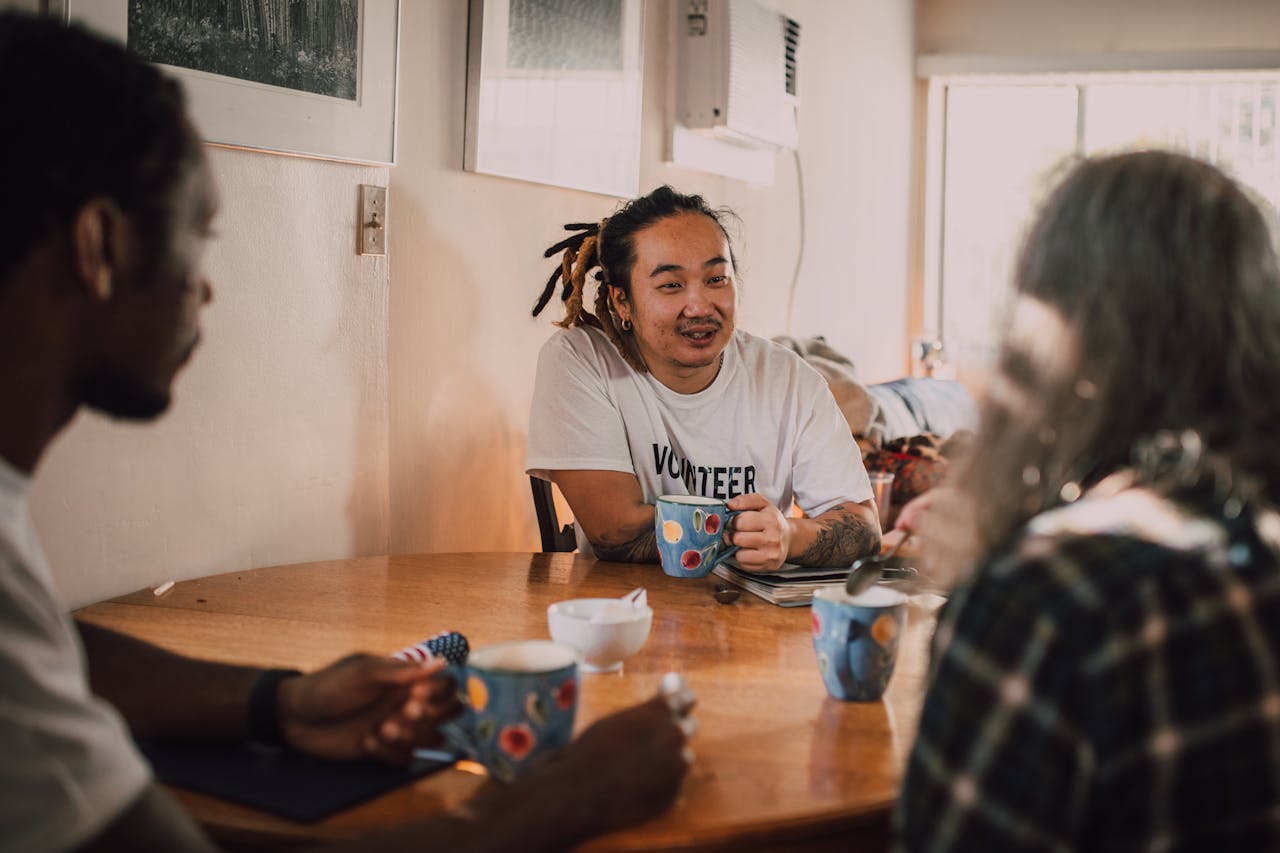 Group of diverse volunteers enjoying coffee and conversation indoors.